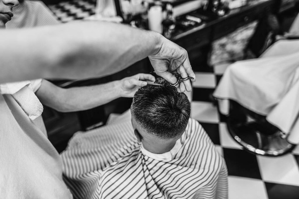 Men's haircut. Haircut with scissors. Black and white photo. - Photo, image