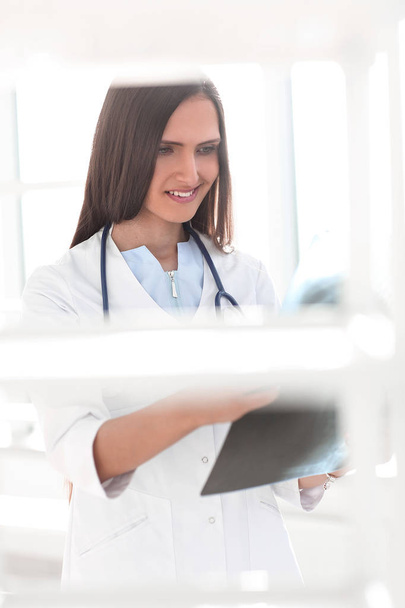 фоновое изображение улыбающейся женщины-врача с рентгеном пациента
 - Фото, изображение