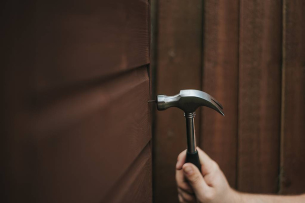 Closeup shot of a hammer tool on a wooden brown background - Φωτογραφία, εικόνα