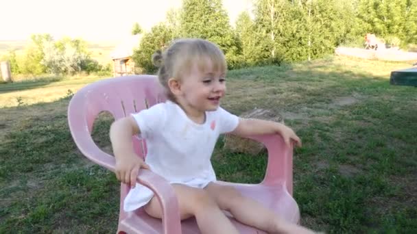 little girl climbs down from the chair - Filmagem, Vídeo