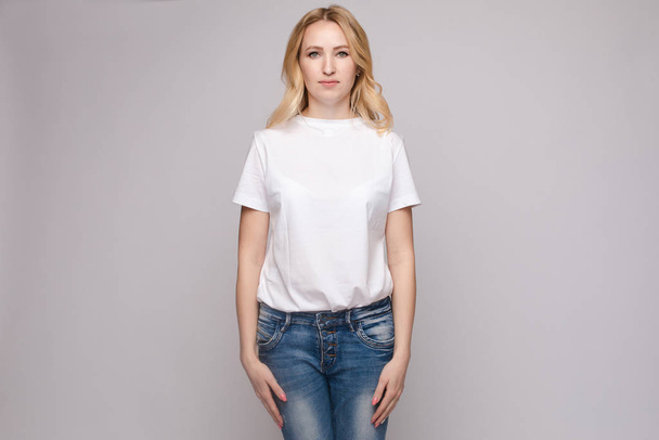 Slim donna indossa camicia bianca e jeans in piedi ferma
 - Foto, immagini