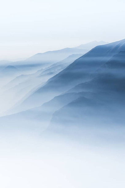 Beautiful shot of high white hilltops and mountains covered in fog - Fotografie, Obrázek