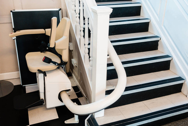 Λευκή σκάλα σε σκάλα για άτομα με ειδικές ανάγκες και ηλικιωμένους εσωτερικούς χώρους στο σπίτι ή το σχολείο και γραφείο για δωρεάν υπηρεσία. - Φωτογραφία, εικόνα