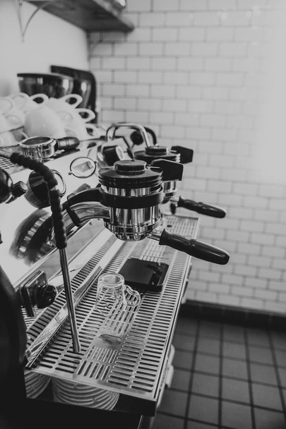 Closeup black and white shot of a coffee machine at a cafe - Foto, afbeelding