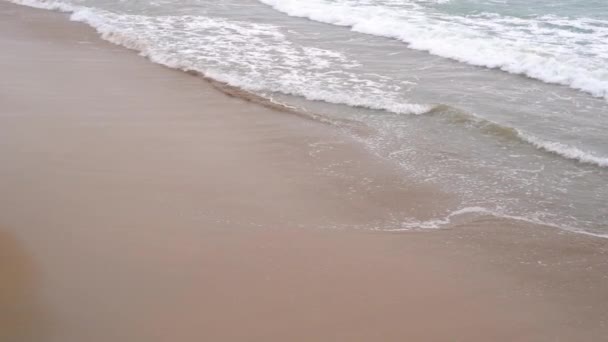 Tranquillo surf serale sull'oceano. Onde schiumose riempiono la spiaggia di sabbia. Il concetto di calma e pacificazione
 - Filmati, video