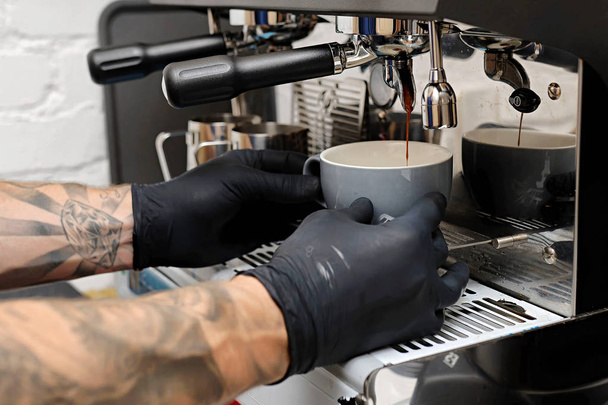 Nahaufnahme von Espresso, der aus der Kaffeemaschine ausgeschenkt wird. professioneller Kaffee - Foto, Bild