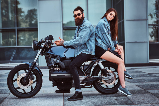 Πορτρέτο του ζευγαριού σε denim σακάκια με μοτοσικλέτα - Φωτογραφία, εικόνα