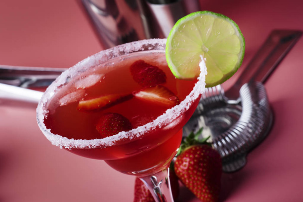 Strawberry red margarita alcoholic cocktail with tequila, liqueur, berries, lime juice, sugar and ice, pink background, copy space - Photo, Image