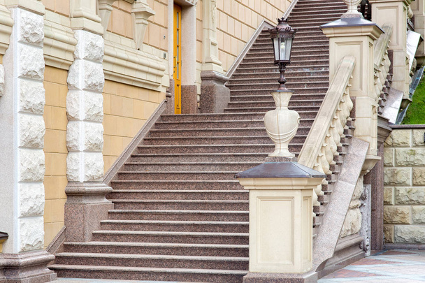 architectural stone staircase with railings and balustrades with a pedestal for a stone vase with an iron street lamp in retro style. - Foto, Imagem