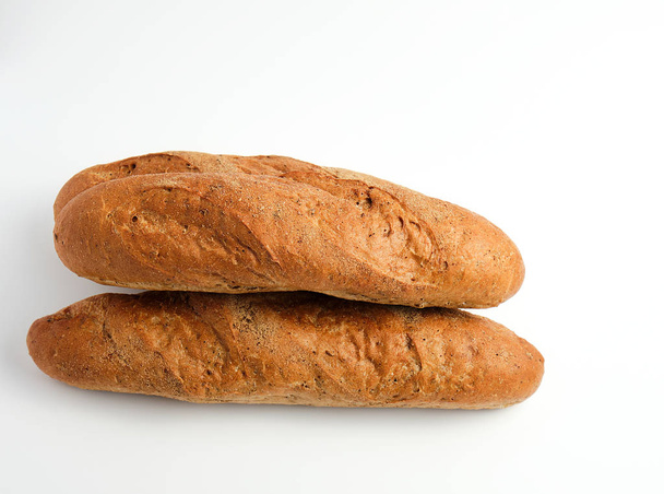 stack of whole baked baguettes from rye flour on a white backgro - Photo, Image