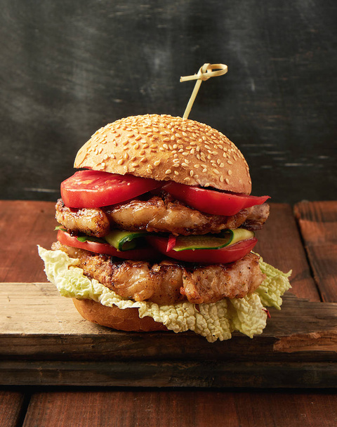 Hamburger mit Schweinefleisch gebratenem Steak, roten Tomaten, frischen runden Brötchen w - Foto, Bild