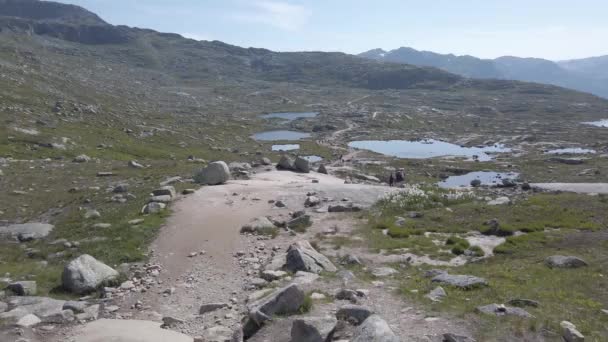 26 Temmuz 2019. Trolltunga üzerinde Norveç turistik rota. İnsanlar turistler thetrolltunga ince güneşli havalarda Norveç dağlarında yürüyüş gidin. Yürüyüş sırt çantası teması - Video, Çekim