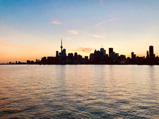 A wide shot of beautiful urban city skyline taken at sunset with the pretty sky and the sea - Foto, Bild