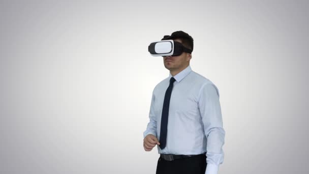 Businessman in VR glasses and interacting with virtual reality objects on gradient background. - Footage, Video