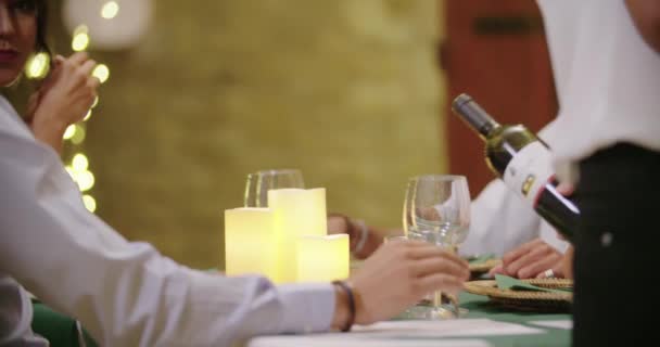 Waiter pouring red wine in woman glass while people, talking,eating,drinking during romantic gourmet gathering dinner or lunch.Shiny lighting.Medium shot. Friends italian trip in Umbria.4k slow motion - Metraje, vídeo