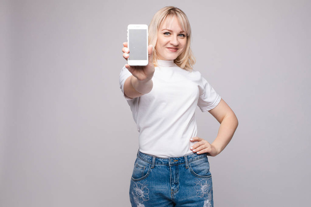 Kaunis tyttö osoittaa matkapuhelimeen.Studio muotokuva kaunis valkoihoinen
 - Valokuva, kuva