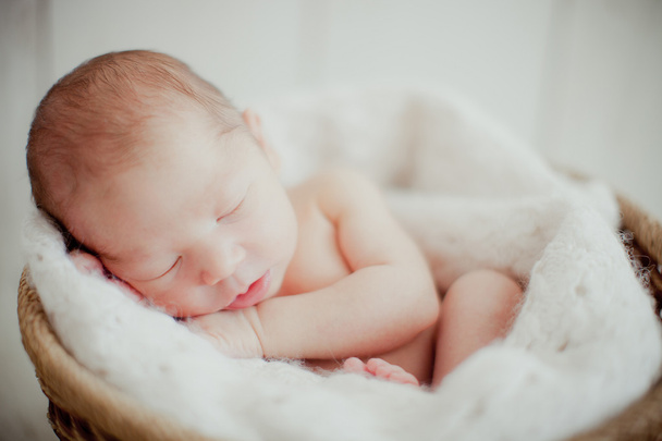 Новорожденный ребенок спит в корзине - Фото, изображение