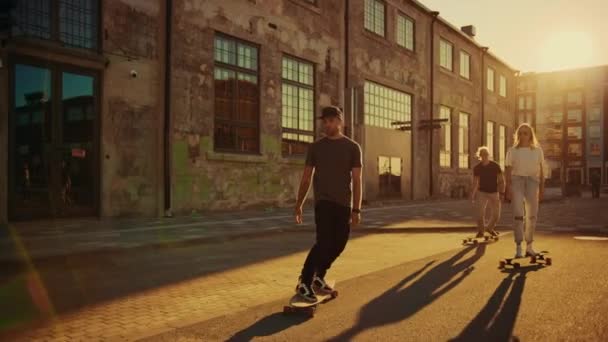 Group of Girls and Boys on Skateboards Through Fashionable Hipster District. Beautiful Young People Skateboarding Through Modern Stylish City Street. Moving Slow Motion Camera Shot. Golden Hour - Кадры, видео