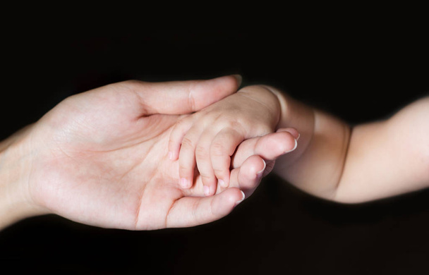 Baby, menselijke hand, moeder aanraken - Foto, afbeelding