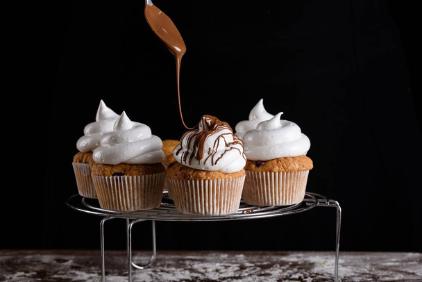 ラズベリー、ホワイトクリーム、チョコレートアイシングのおいしい風味のカップケーキ. - 写真・画像