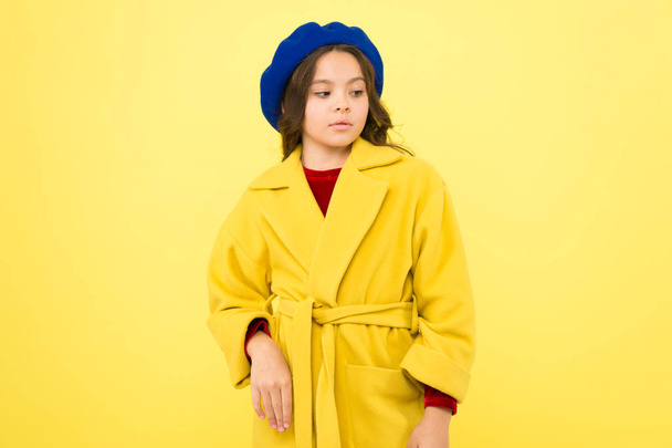 Everyone needs coat this winter. Girl fashionable cute model wear yellow wool coat. Pensive child in warm clothes. Personal styling and bespoke tailoring. Feeling cozy and comfortable in proper coat - Photo, image