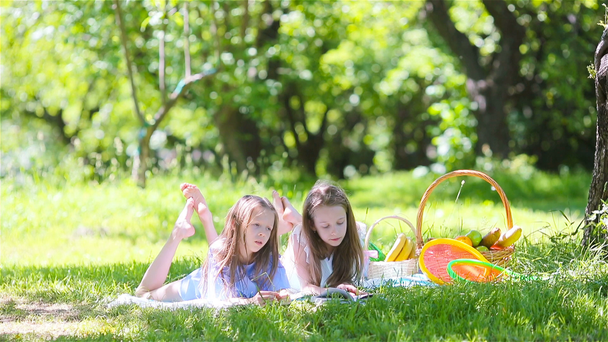 Dwójka małych dzieci na pikniku w parku - Materiał filmowy, wideo