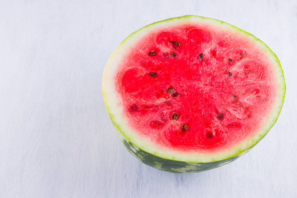 Half of watermelon on white background. Sliced watermelon on light background. Healthy food for vegan. Top view - Foto, afbeelding