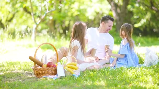 Szczęśliwy ojciec i małe córeczki zrelaksować się nad jeziorem - Materiał filmowy, wideo