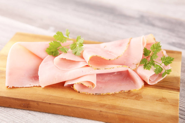 Sliced ham with parsley on table. Fresh prosciutto. Pork ham sli - Photo, Image