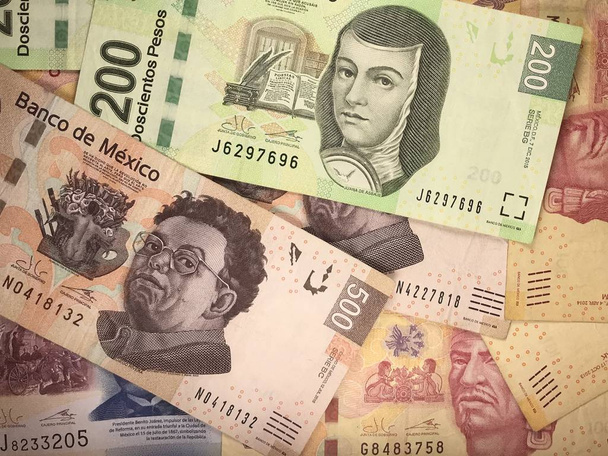 Billetes de peso mexicano distribuidos aleatoriamente sobre una superficie plana
 - Foto, imagen