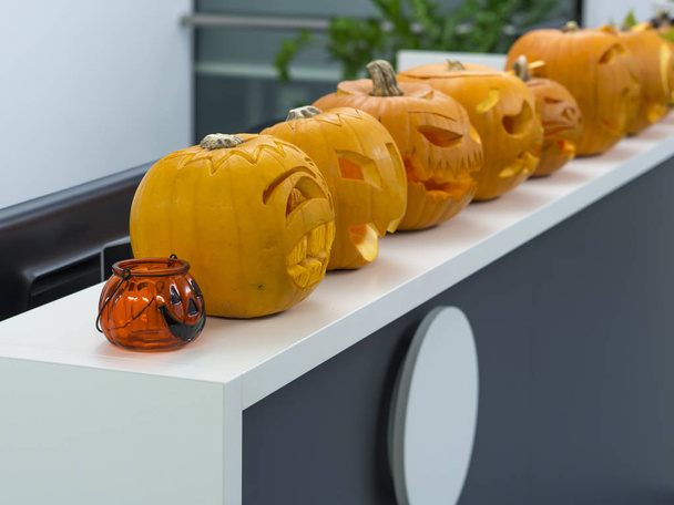 Группа Хэллоуина большая оранжевая тыква украшена страшным лицом. Фонарь Jack O на белом фоне стола
 - Фото, изображение