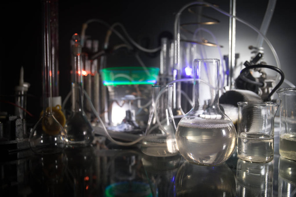 Temat farmacji i chemii. Kolby szklane testowe z roztworem w laboratorium badawczym. Nauka i doświadczenie medyczne. Laboratoryjne probówki na ciemnym, stonowanym tle - Zdjęcie, obraz