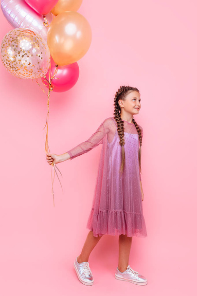 Happy and beautiful teen girl holding a bunch of colorful balloo - Φωτογραφία, εικόνα
