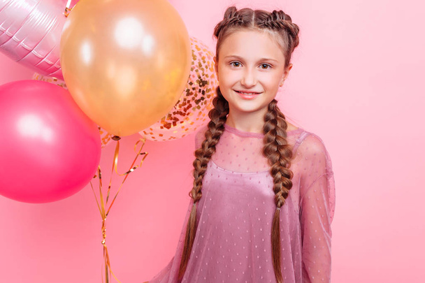 Happy and beautiful teen girl holding a bunch of colorful balloo - Valokuva, kuva