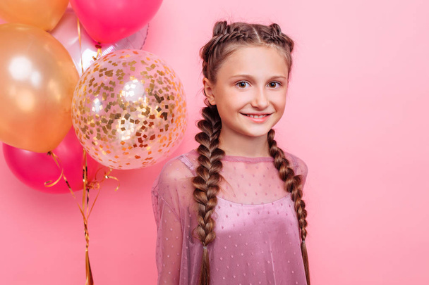 young girl or teenage girl in dress holding a bunch of helium ba - Foto, Imagem