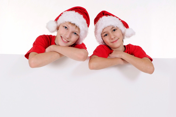 kids in santa hats with board - Foto, Imagen