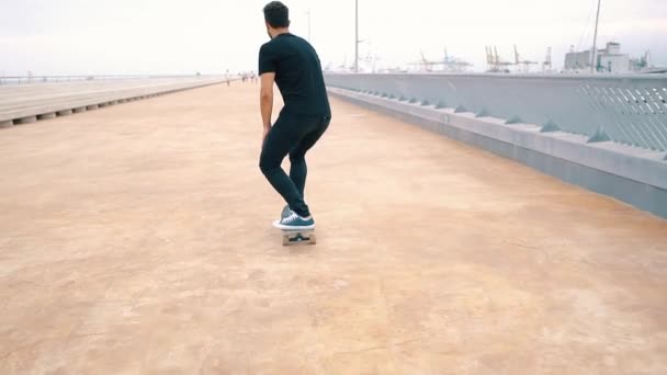 スケートボーダーは、近代的な市内のテラスでスケートボードに乗ります. - 映像、動画