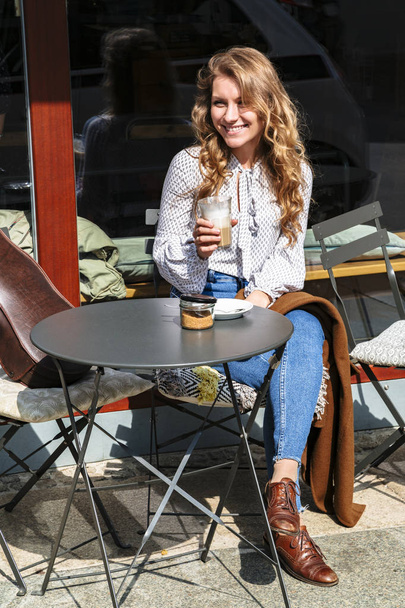Girl violinist sitting on coffee break in cafe - Фото, зображення