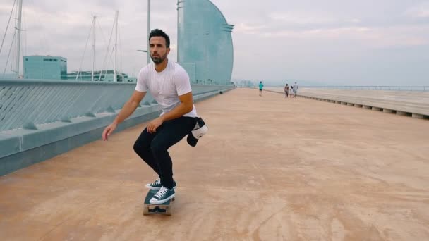 スケートボーダーは、近代的な市内のテラスでスケートボードに乗ります. - 映像、動画