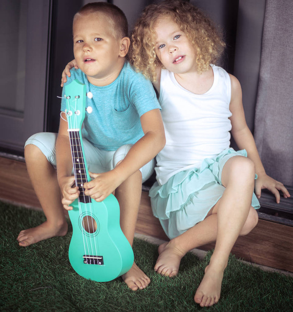 Portrait of a cute kids with ukulele - Valokuva, kuva