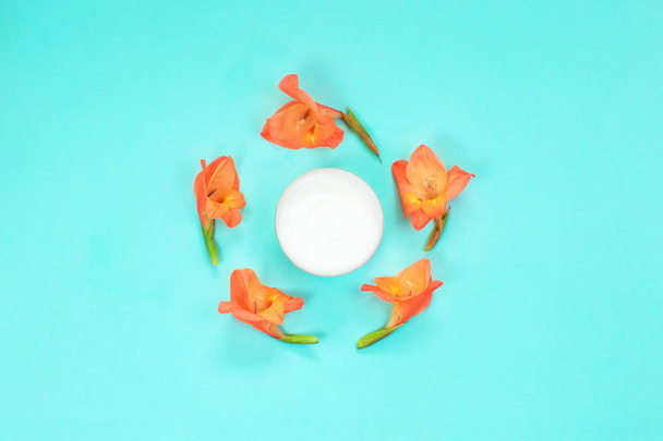 Καλλυντικό δοχείο κρέμας με λουλούδια κρέμα σώματος - Φωτογραφία, εικόνα