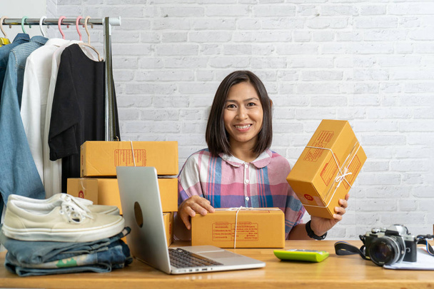 アジアの女性は、梱包段ボール箱、電子商取引のアイデアコンセプトを保持中小企業の所有者を起動します - 写真・画像