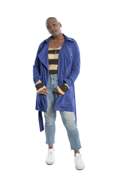 Black African American fashion model with bald hairstyle confidently posing with a vibrant blue colored jacket for fall collection.  Depicts fashion design and clothing apparel - Foto, Imagen