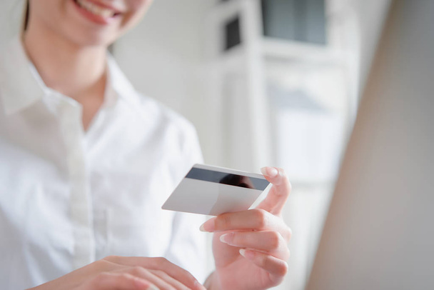Посмішка щасливо Азіатська жінка покупки онлайн і проведення кредитних карт і введіть платіжний код для продукту. - Фото, зображення