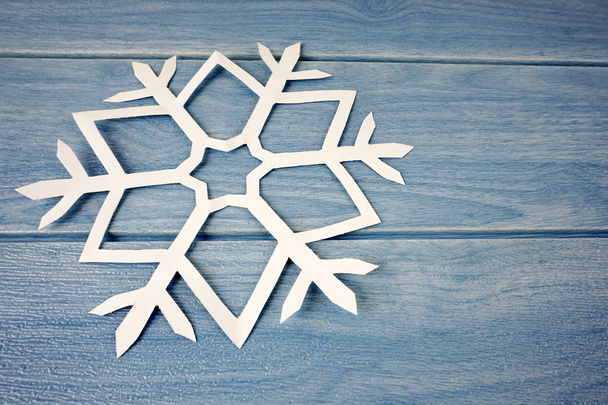 floco de neve de papel de origami na superfície da mesa de madeira azul
  - Foto, Imagem