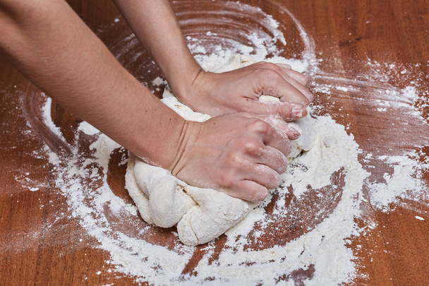 Female hands chef close-up, knead the dough, cook the dough on a table - Фото, зображення
