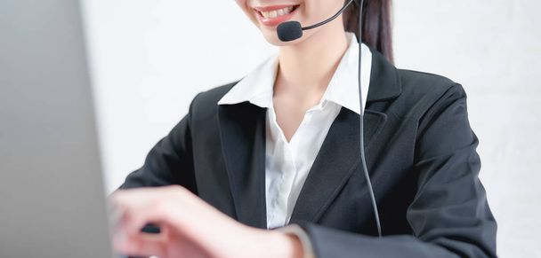 Sorridente donna asiatica consulente indossare microfono auricolare del servizio clienti operatore telefonico sul posto di lavoro. - Foto, immagini