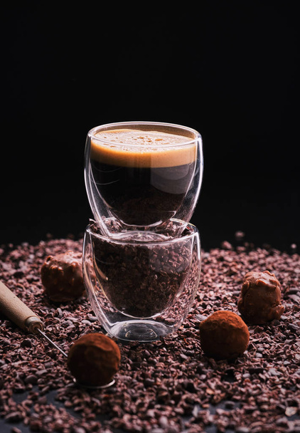 Горячий кофе эспрессо на темном фоне с бобами какао и ок
 - Фото, изображение