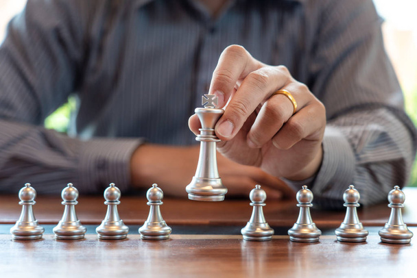 Hombre de negocios tomar una figura de rey jaque mate en el tablero de ajedrez gam
 - Foto, imagen