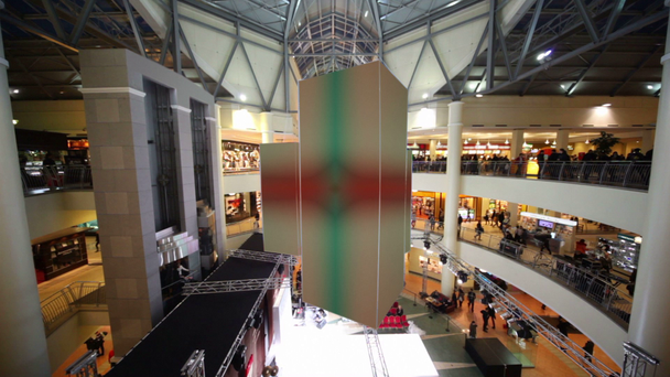 мерехтливі кубики висять зі стелі, у висотному торговому центрі
 - Кадри, відео